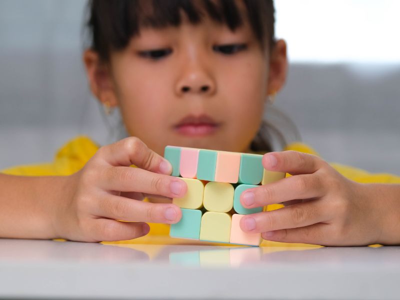 Menina brincando com um cubo mágico