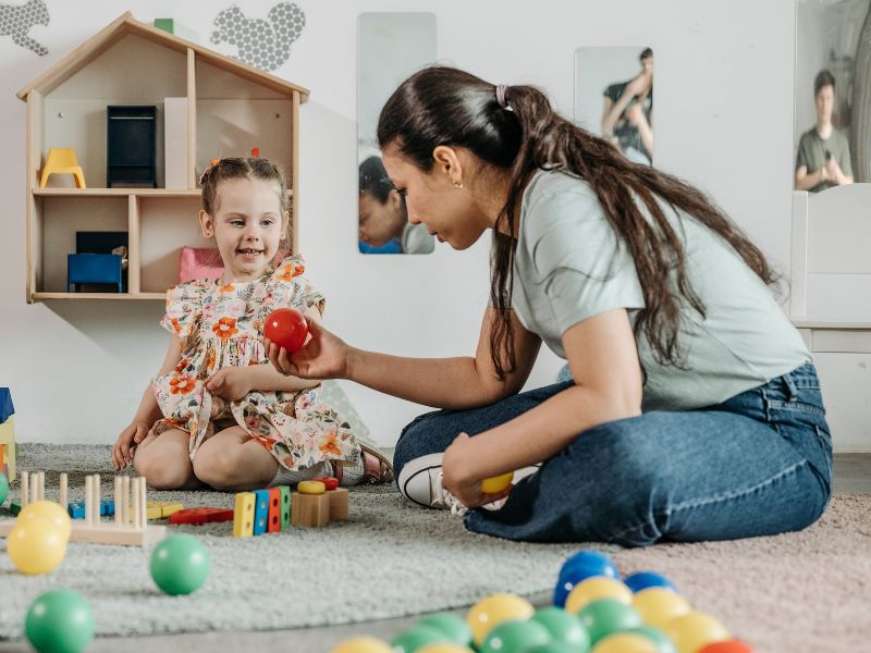 Mulher brincando com menina pequena